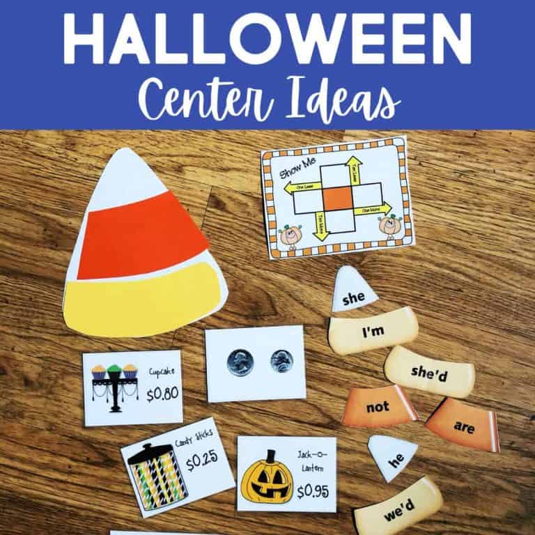 A collection of Halloween-themed learning materials on a wooden surface, featuring halloween word puzzles, a large candy corn cutout, coin images, price cards with cupcakes and jack-o-lanterns, and a festive game board.