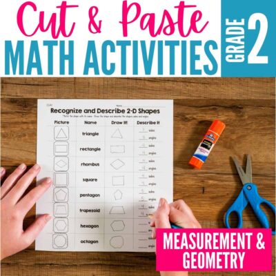 A student’s hands work on a Cut and Paste Math Activities for Second Grade - Measurement and Geometry worksheet, with a glue stick and blue scissors nearby on a wooden table. Text reads: Cut & Paste Math Activities Grade 2.