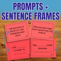 Four red Mathematical Practices Partner and Group Discussion Cards rest on a wooden surface, displaying discussion prompts and sentence frames for classroom use. Above them, "Prompts + Sentence Frames" appears in bold blue and white letters.