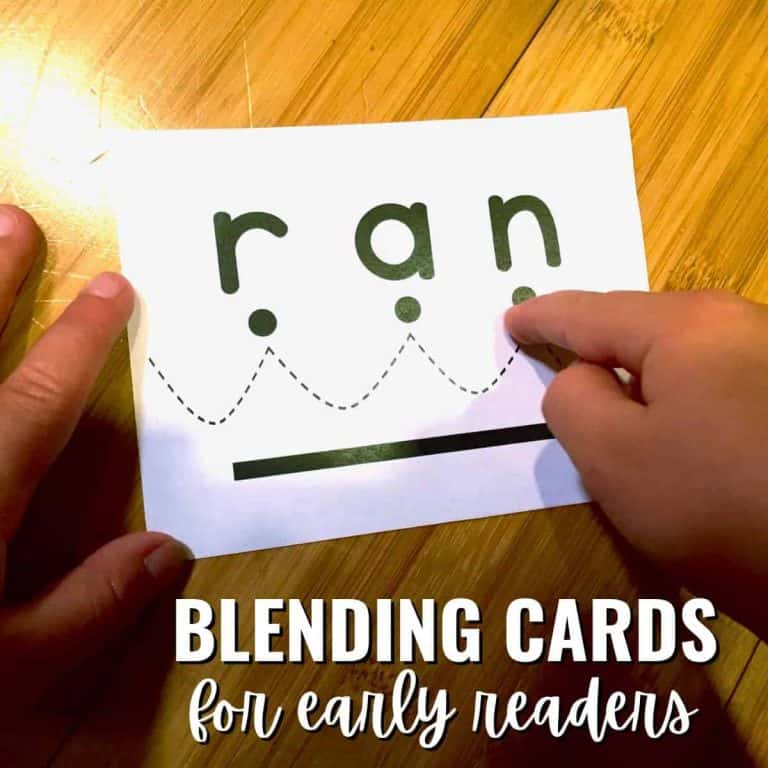 A child's hands hold a blending card with the word "ran" in lowercase letters, each letter above a dot and a dashed curved line connecting them. Text reads: Blending cards for early readers.