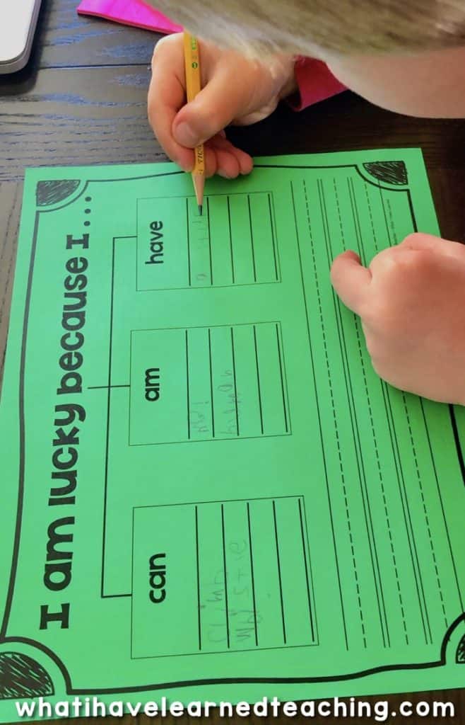 I Am Lucky St. Patrick's Day Craftivity 6 A child writes on a green St. Patrick’s Day Craftivity worksheet titled I am lucky because I... with sections labeled have and can. Spaces for writing are provided, and the worksheet sits on a dark table. whatihavelearnedteaching.com is visible at the bottom.