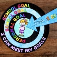 A colorful Goal Setting Craft bullseye chart with rings labeled “SCHOOL GOAL,” “PERSONAL GOAL,” and “I CAN MEET MY GOALS,” plus an arrow pointing to a drawing of a girl with the words “Olivia’s Goals” written on it.