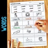 A child holds a Long Vowel Teams AI & AY Worksheets & Activities No-Prep Phonics Worksheet titled Match & Write, featuring images and matching words like coach, soak, oar, foam, and cloak. "WORDS" is written vertically on the side.