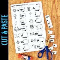 A worksheet from Long Vowel Teams AI & AY Worksheets & Activities No-Prep Phonics Worksheets shows images and words missing endings, with cut-out pieces, glue stick, scissors, and a blue CUT & PASTE banner on the left.
