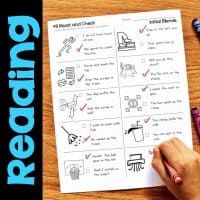 A child completes an “Initial Blends S-Blends & TW Worksheets & Activities No-Prep Phonics Worksheets” page, featuring illustrated sentences with checkboxes and the word “Reading” in blue vertically on the left, checking answers with a red pencil on a wooden table.