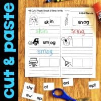 The Initial Blends S-Blends & TW Worksheets & Activities No-Prep Phonics Worksheets feature a cut & paste worksheet with picture-word activities, letter tiles, colored marker answers, and words like skin, snag, and smog on a wooden table.