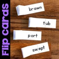 Three stacks of Onset and Rime Matching Cards, Word Family Flip Cards & Word Lists with words like "brawn," "tub," "port," and "swept" divided by a dashed line, displayed on wood. Text “Flip Cards” appears at left.