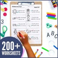 A child works on Short Vowel CVC Sentence Writing Worksheets on a clipboard, surrounded by school supplies. A circular label displays "200+ WORKSHEETS" in bold white text.