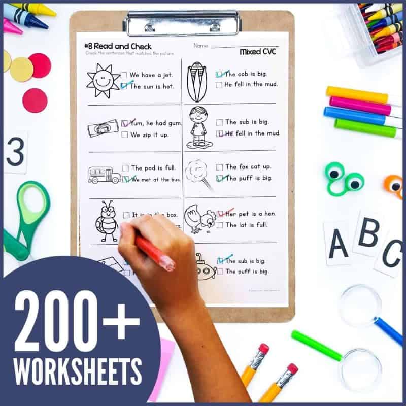 CVC Sentences Worksheets 2 A child works on Short Vowel CVC Sentence Writing Worksheets on a clipboard, surrounded by school supplies. A circular label displays "200+ WORKSHEETS" in bold white text.