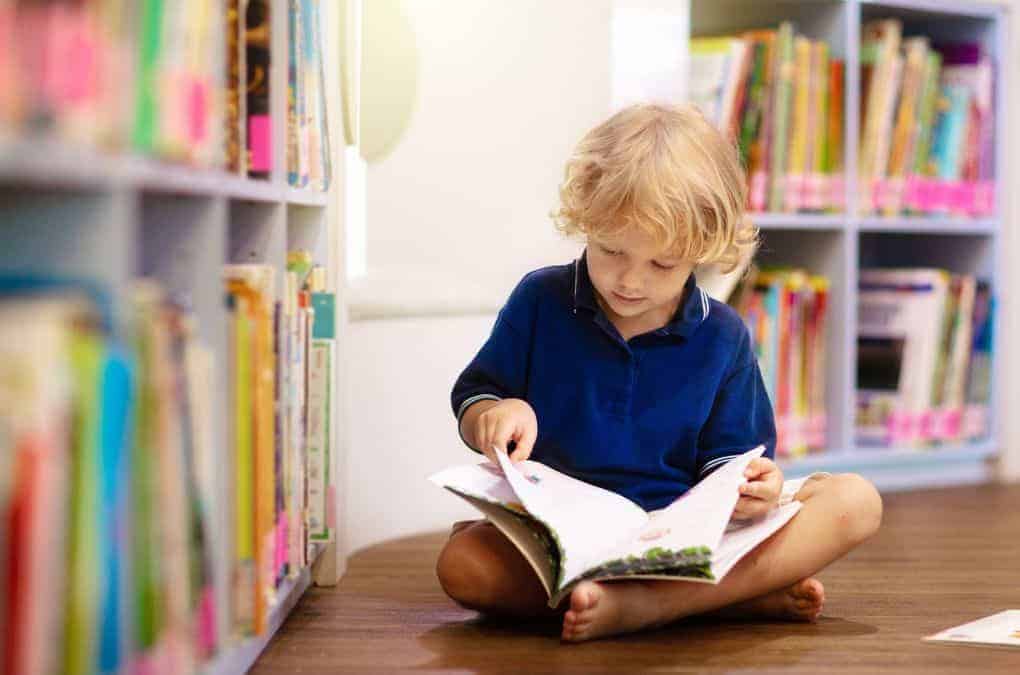 boy in a blue shirt reading a book.